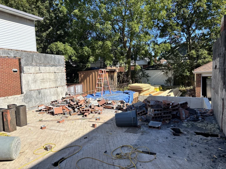 Backyard work area with brick and debris sorted into piles