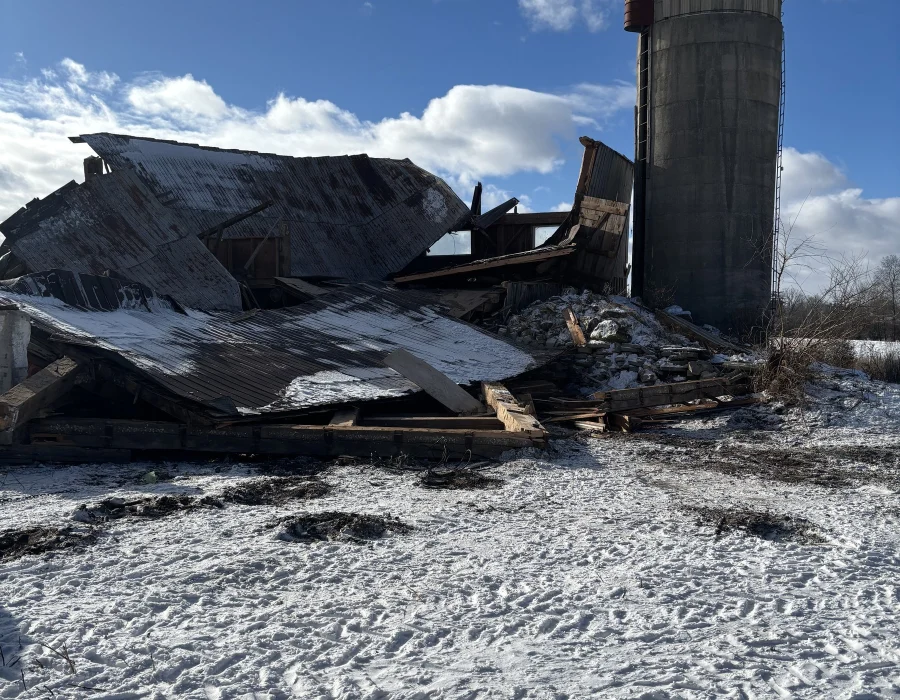 Barn roof and walls down beside the silo, ready for cleanup