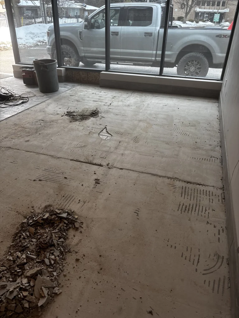 Storefront unit with the old flooring scraped up and piled