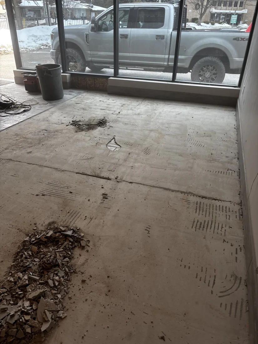 Storefront unit with the old flooring scraped up and piled