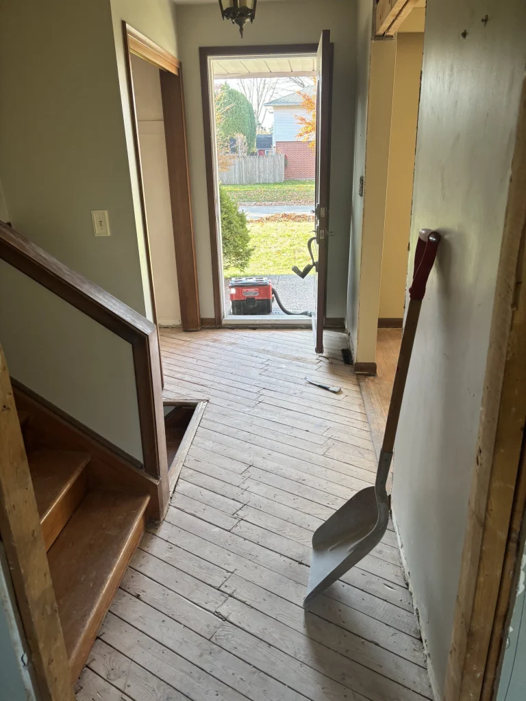 Front hall with the flooring torn up to the subfloor