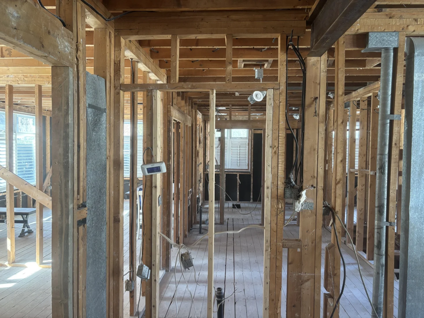View down a gutted hallway through bare wall framing