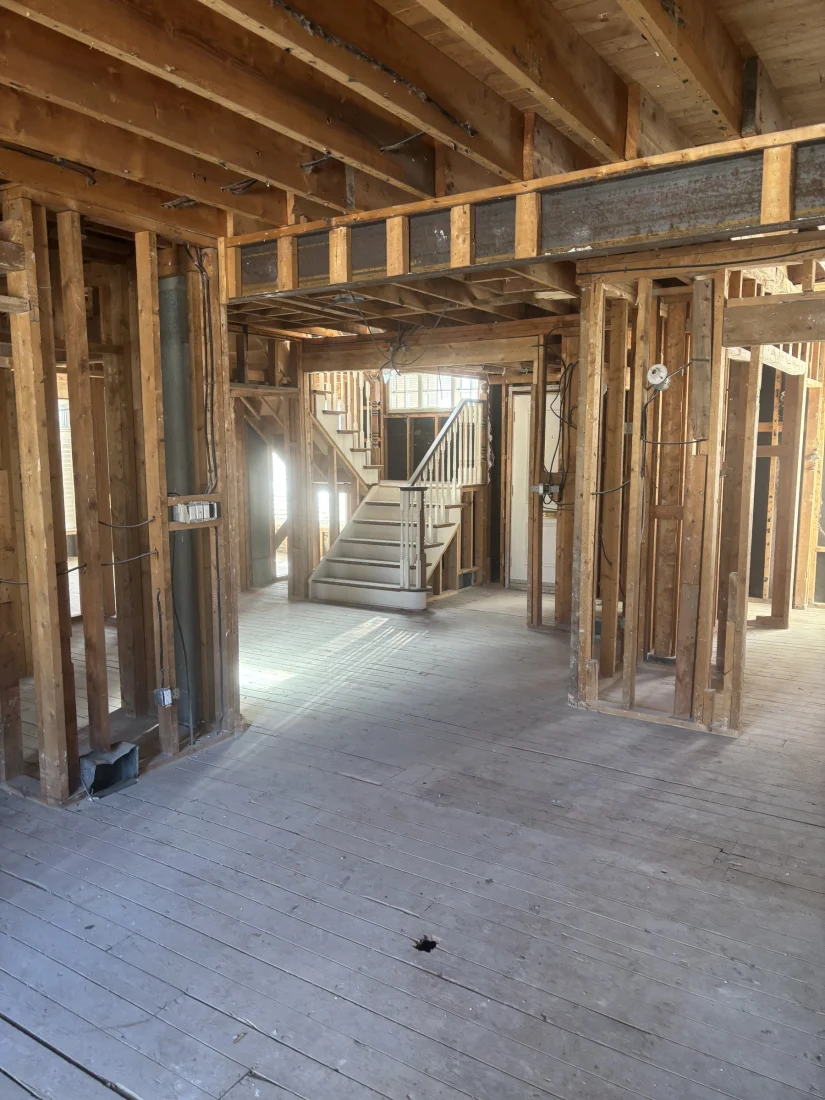 Gutted main floor with the staircase and studs exposed
