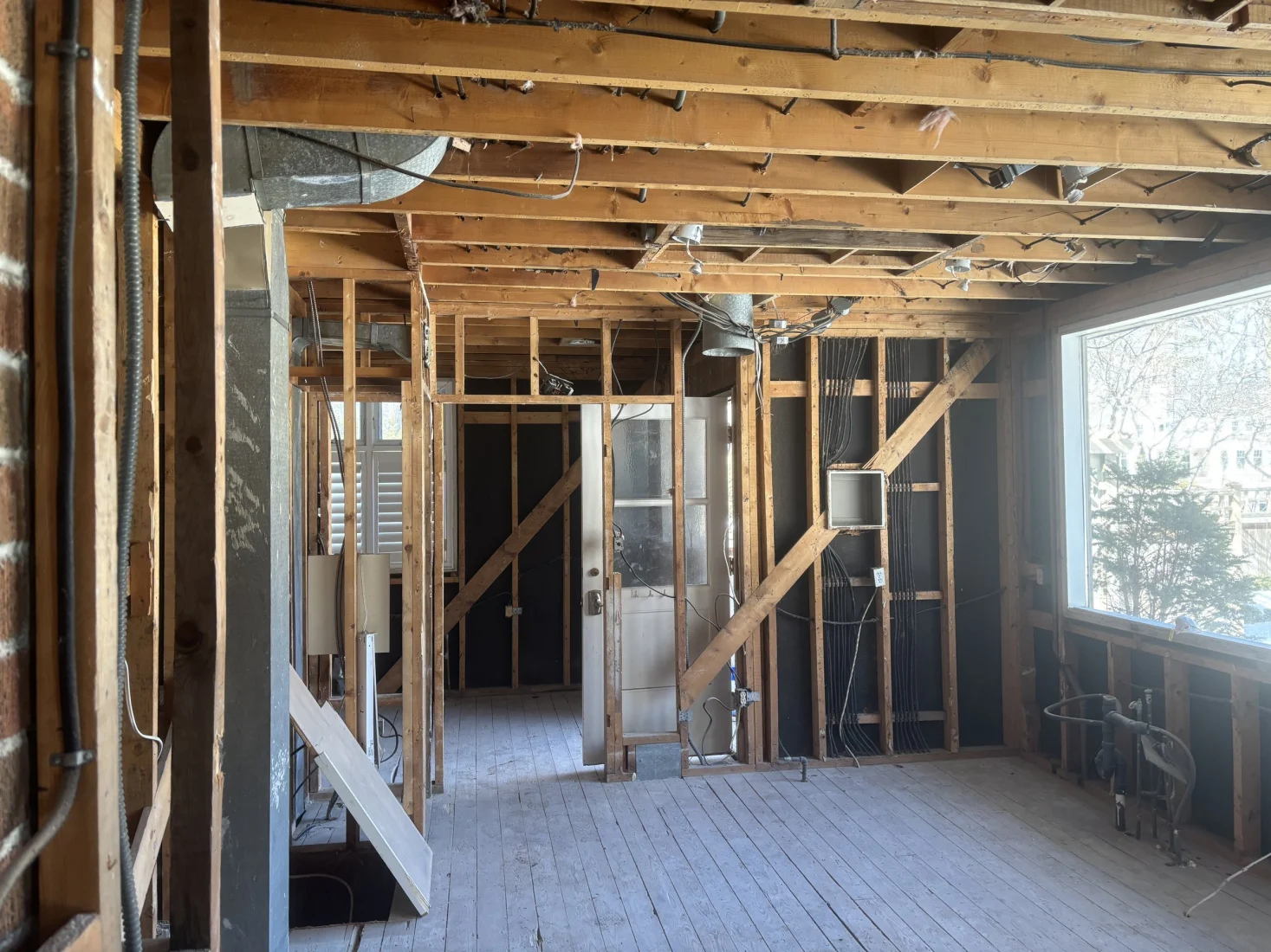 Main floor gutted to the studs, looking toward the front entry
