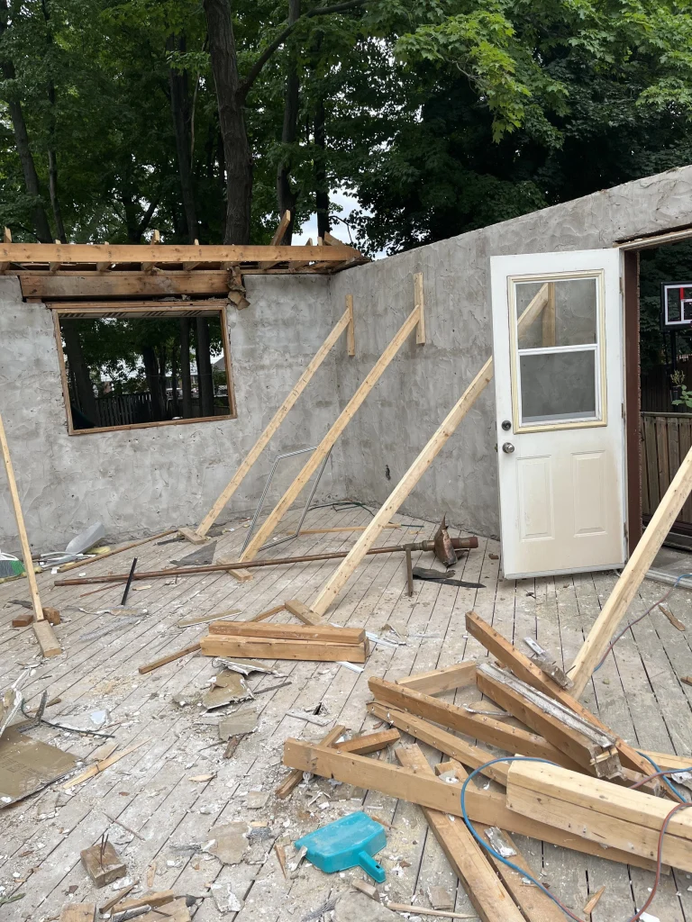 Outbuilding walls and framing being taken down by hand