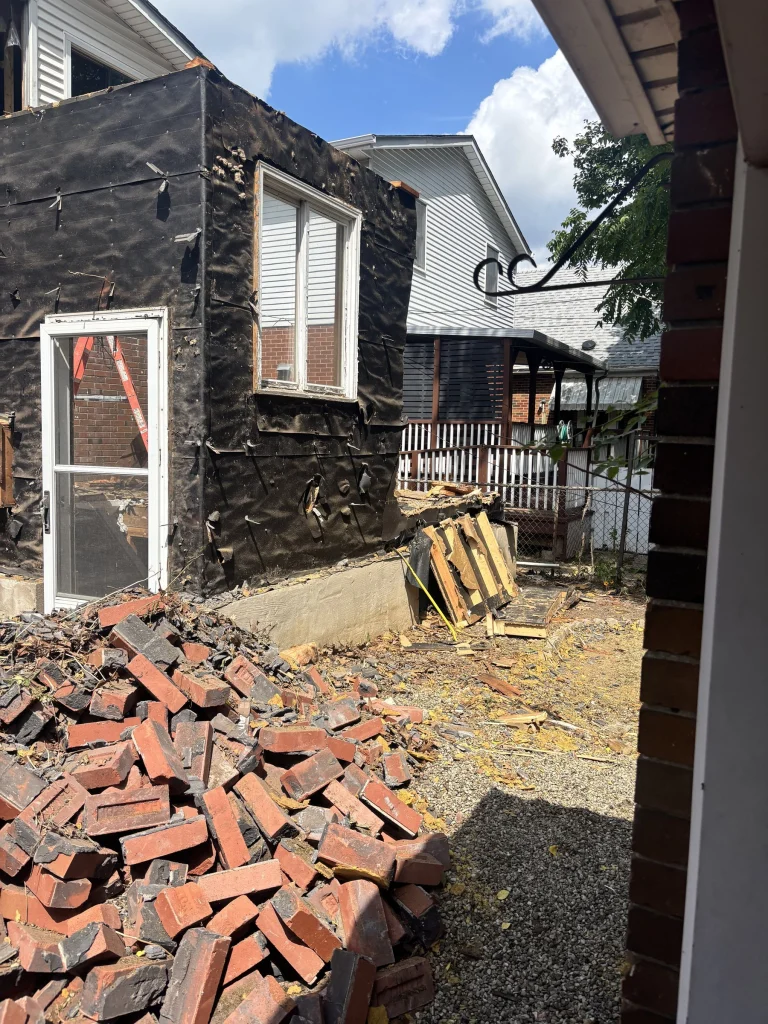 Pile of salvaged brick beside the stripped wall