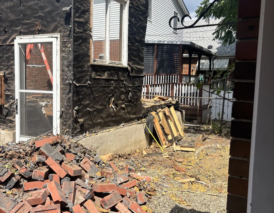 Pile of salvaged brick beside the stripped wall
