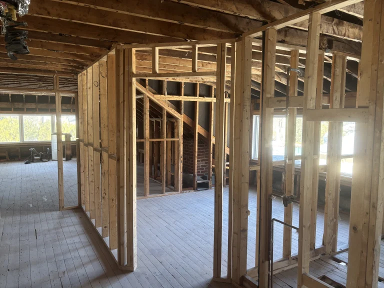 Second floor room gutted to the studs with an exposed brick chimney