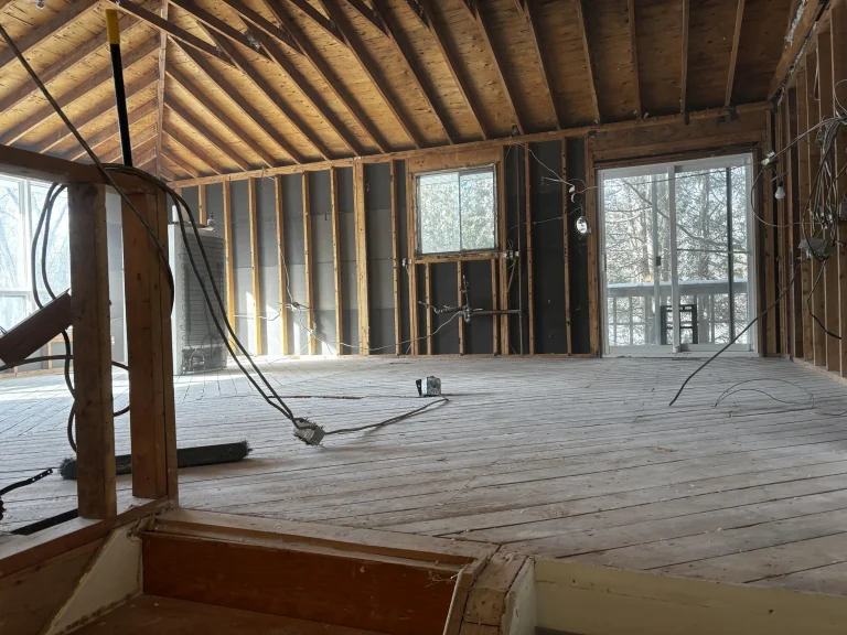 Room with a vaulted ceiling stripped to the subfloor and framing