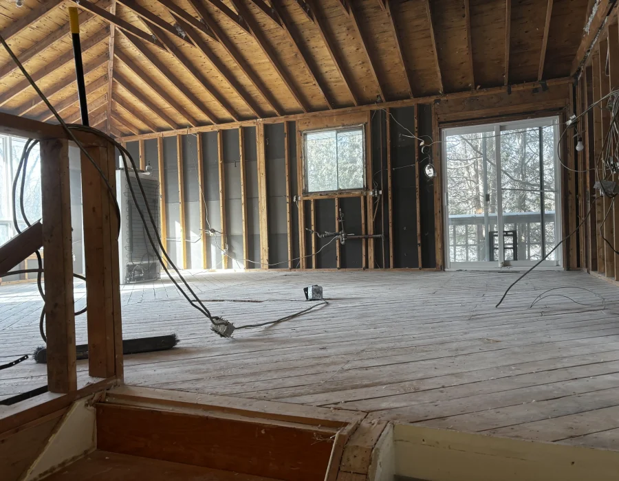 Room with a vaulted ceiling stripped to the subfloor and framing